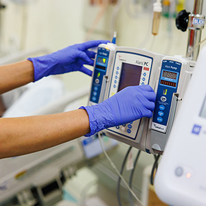 Gloved hands operating medical equipment